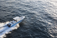 High Angle View Of Couple Driving Speedboat On Sea