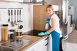 Woman Cleaning Induction Stove In Kitchen