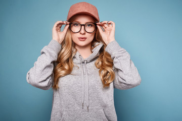 Cute positive blonde woman in a pink baseball cap