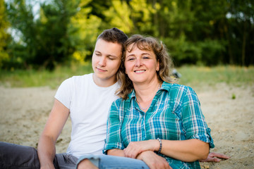 Wall Mural - Adult son relaxing with his mother beside him