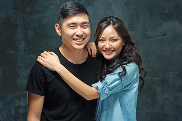 Wall Mural - Portrait of smiling Korean couple on a gray