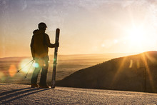 A Skier Stands On Top Of A Mountain Watching The Sunrise In Pennsylvania.