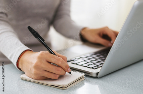 Plakat Bizneswoman ręka pracuje z nowym nowożytnym komputerem i writing