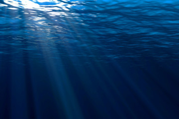 deep blue ocean waves from underwater background, light rays