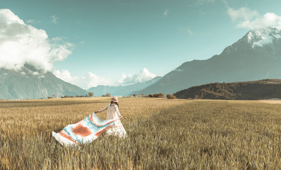 Beautiful girl walking through the wheat field