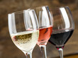 Glasses of red, white and rose wine on a dark wood background