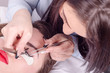 © focusandblur - Girl beautician or a worker make eyelashes client or customer in
