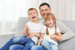 © Africa Studio - Happy father with children on couch
