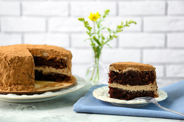 Wall Mural - Slice of tasty chocolate cake on napkin against brick wall background