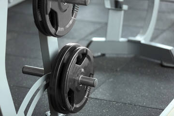 Wall Mural - Rack with weight plates in gym, close up view