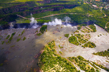 Wall Mural - Aerial view of the Zambezi river right before Victoria Falls.  Clouds and mist rising up from the falls.