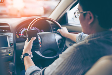 Man using smartphone while driving the car