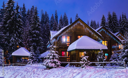 Fotografie, Obraz Christmas winter landscape, old wooden house, surrounded by snow-capped fir tree