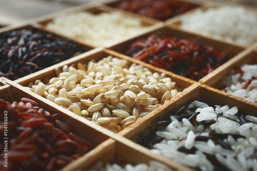 Different types of rice in wooden boxes closeup