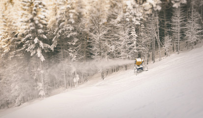 Wall Mural - The snow-gun is making snow on hill of mountain