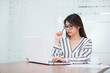 © interstid - Beautiful young Asian woman thinking while working with laptop