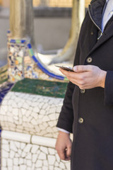 Man using smart phone in front sculpture