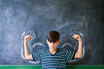 Wall Mural - Strong Male Child Showing Muscles In Classroom At Lesson