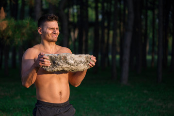 Happy, young, good looking guy exercising in nature