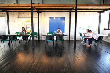 Wall Mural - Young startup group working in modern office. Open space, laptops and paperwork