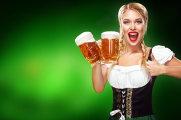 St Patricks Day. Young sexy Oktoberfest waitress, wearing a traditional Bavarian dress, serving big beer mugs on blue background with copy space