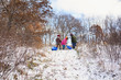 © RooM The Agency - Three children with sledges standing at the top of a hill