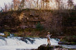 © RooM The Agency - Young boy throwing rocks into a waterfall