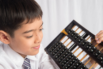 Little boy using abacus to study mathematic education class