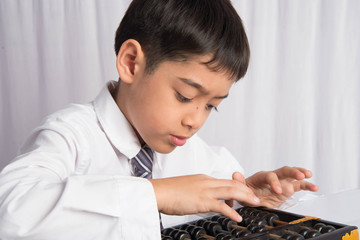 Little boy using abacus to study mathematic education class