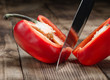 © kucherav - Big kitchen knife cut a bell pepper on wooden table