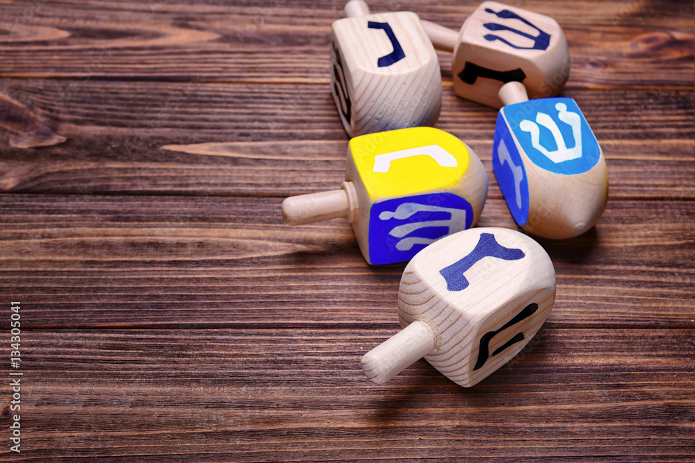 Dreidels for Hanukkah on wooden table, close up