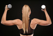 © Africa Studio - Young athletic woman with dumbbells on black background