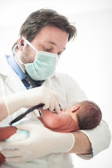 Wall Mural - Pediatrician holding a newborn baby boy in hospital