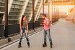 Young couple inline skating. Girl on rollerblades smiling. Cheerful mood and good impressions.