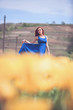 © DC Studio - Woman in blue dress in yellow flower field