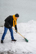 © timonko - man in an orange scarf cleans snow