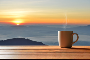 Wall Mural - Morning cup of coffee or tea with mountain background at sunrise