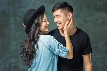 Wall Mural - Portrait of smiling Korean couple on a gray