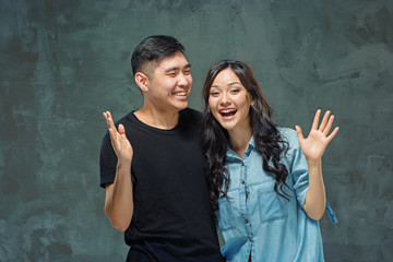 Wall Mural - Portrait of smiling Korean couple on a gray