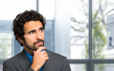 Wall Mural - Portrait of a thoughtful handsome businessman