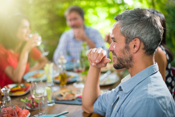 Wall Mural - A man lunching with friends on a terrace table