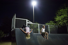 Siblings Playing On Slide At Night 