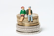 Rentner / älteres Ehepaar sitzt auf Euromünzen
