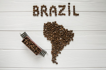  Mapa Brazylii z palonych ziaren kawy na białym drewnianym teksturowanej tło z pociągiem zabawki. Miejsce na tekst