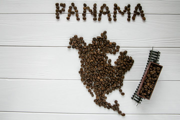 Wall Mural - Map of the Panama made of roasted coffee beans laying on white wooden textured background with toy train. Space for text