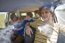 Young People Sitting Inside A Van.