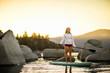 © Erickson Stock - Young woman paddle boarding on a lake.