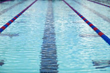 Rippled Surface Of A Swimming Pool With Lane Markers.