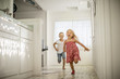 © Erickson Stock - Two little girls have fun running through the house together.