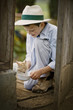 © Erickson Stock - Boy giving a cat some milk from a bowl.